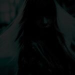 A mysterious silhouette of a person with hair obscuring their face against a dark, moody backdrop.
