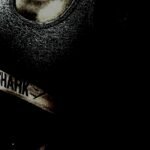 A dimly lit, high-contrast image focusing on sportswear with the brand name visible on the clothing.