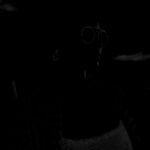 A silhouette of a person with sunglasses and an earring, set against a dark background.