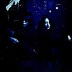 A duo cloaked in shadowy allure, exuding a mysterious vibe against a dark, enigmatic backdrop.