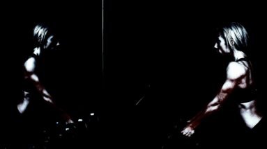 Metalhead Meal Prep: A muscular woman lifting weights, her strong arms illuminated by focused light, reflecting in a dimly lit gym mirror.