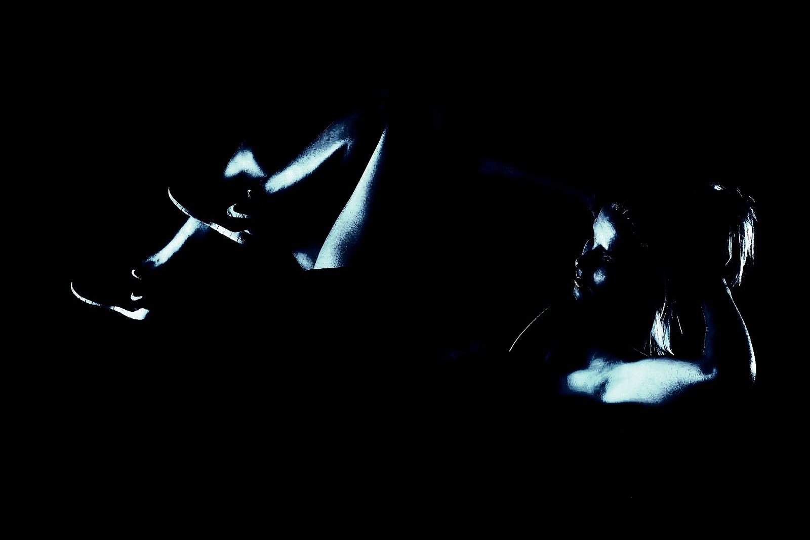 A fit woman in an abstract pose, dimly lit, emphasizing her athletic form against a dark background.