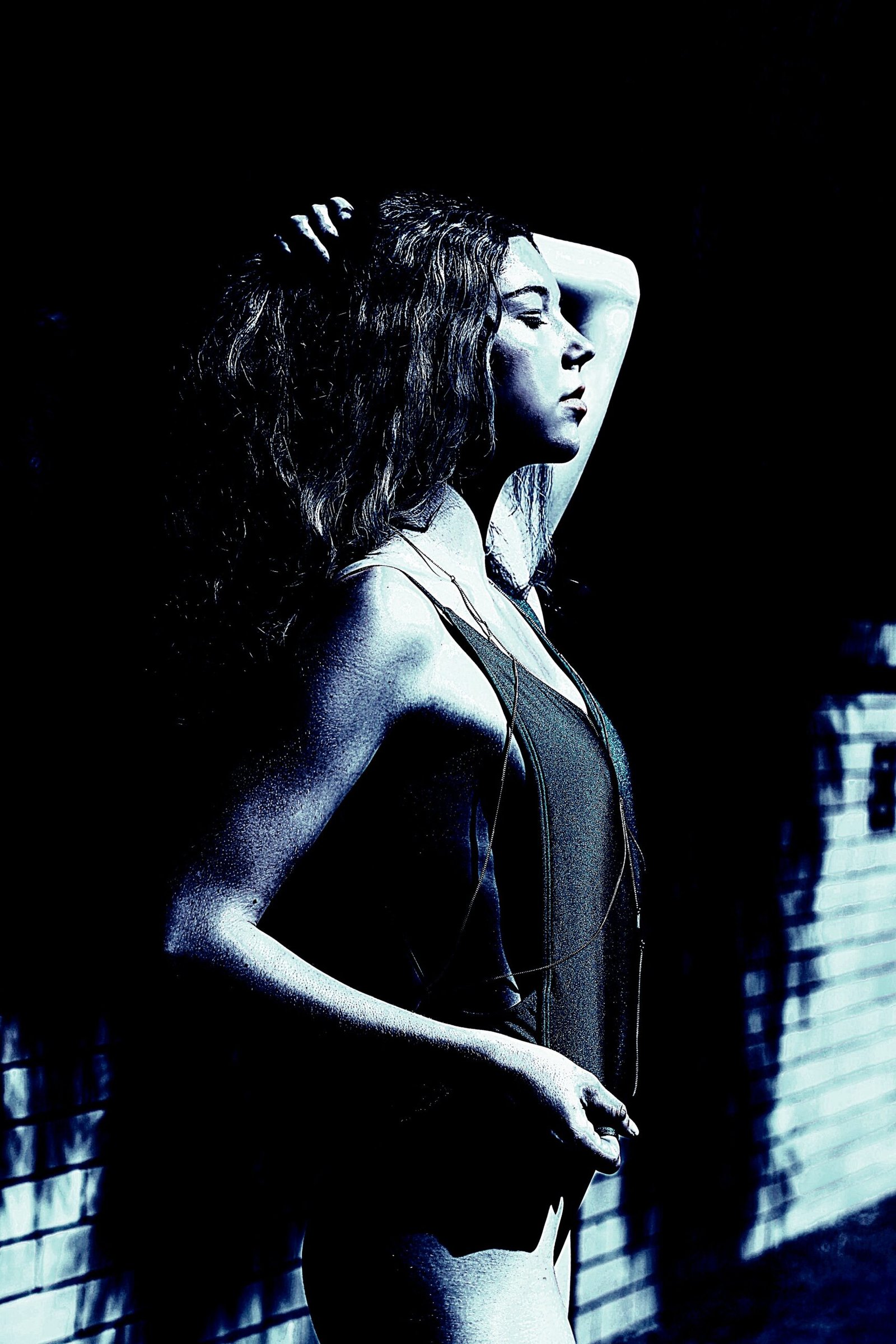 Introspective ambiance with a goth-styled woman in a dark bowling alley, contemplating with a pensive expression.