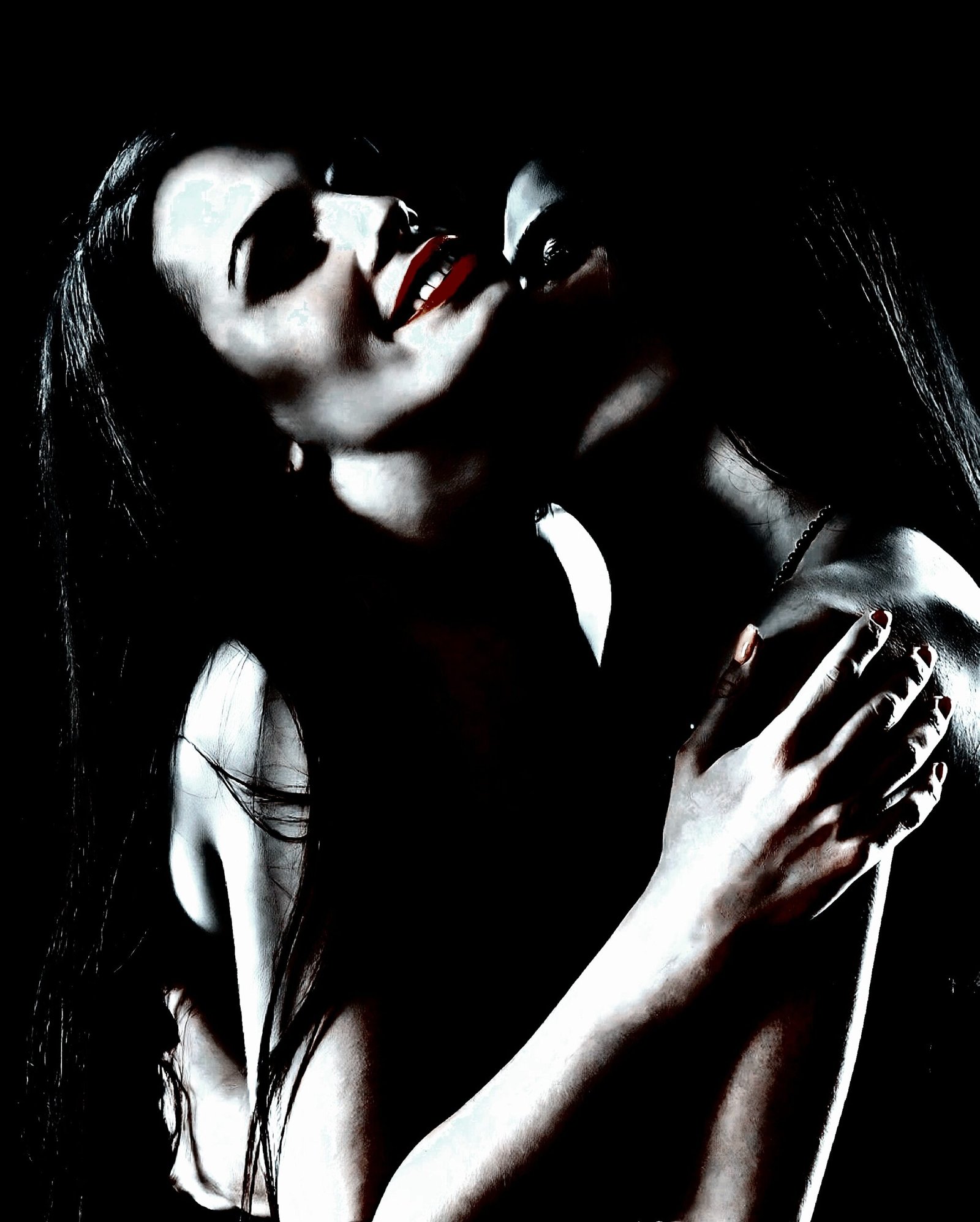 Intense moment between two women sharing an embrace, with a bisexual gothic flair.