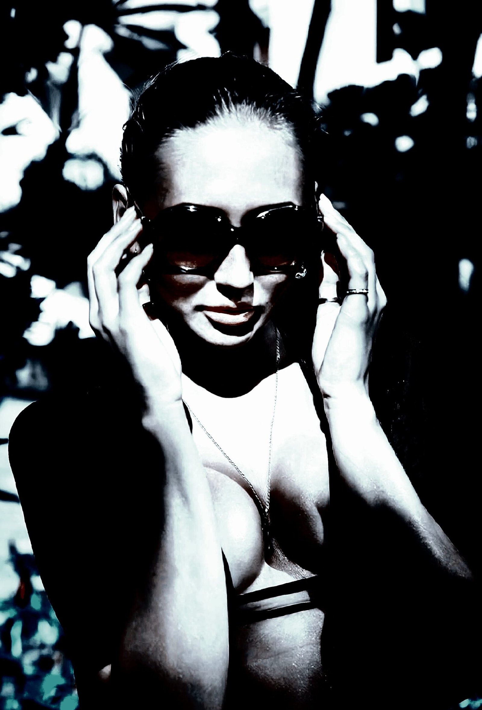 Person framed by nature, adjusting sunglasses, a study in gender fluidity and bold fashion contrast.