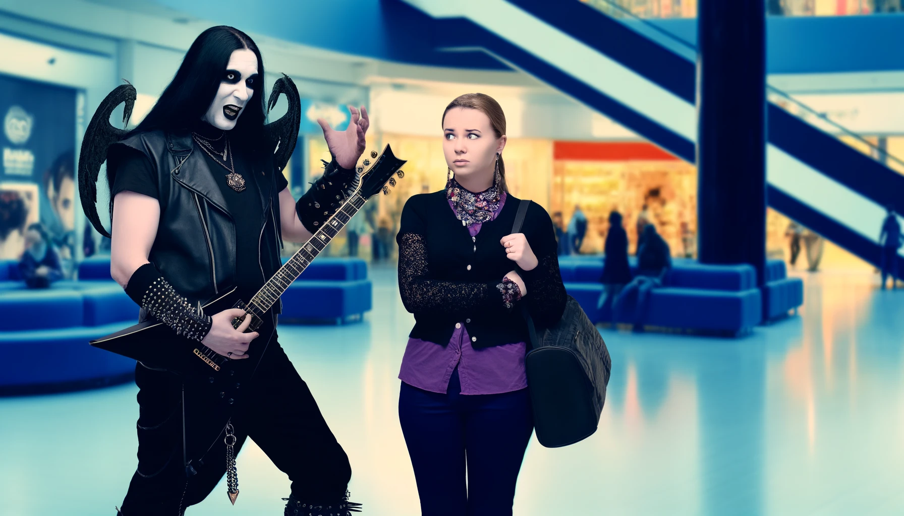Gothic couple changing the music to metal at a nightclub DJ booth, showcasing the concept that mainstream music lacks depth.
