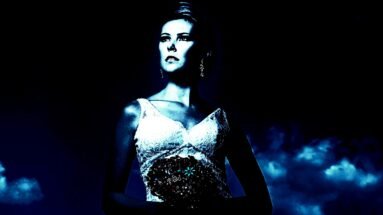 A gothic bride in an elegant dress, imbued with the essence of gothic wedding dresses, stands under a moonlit sky that casts an enigmatic blue glow, highlighting her contemplative expression and intricate lace details.