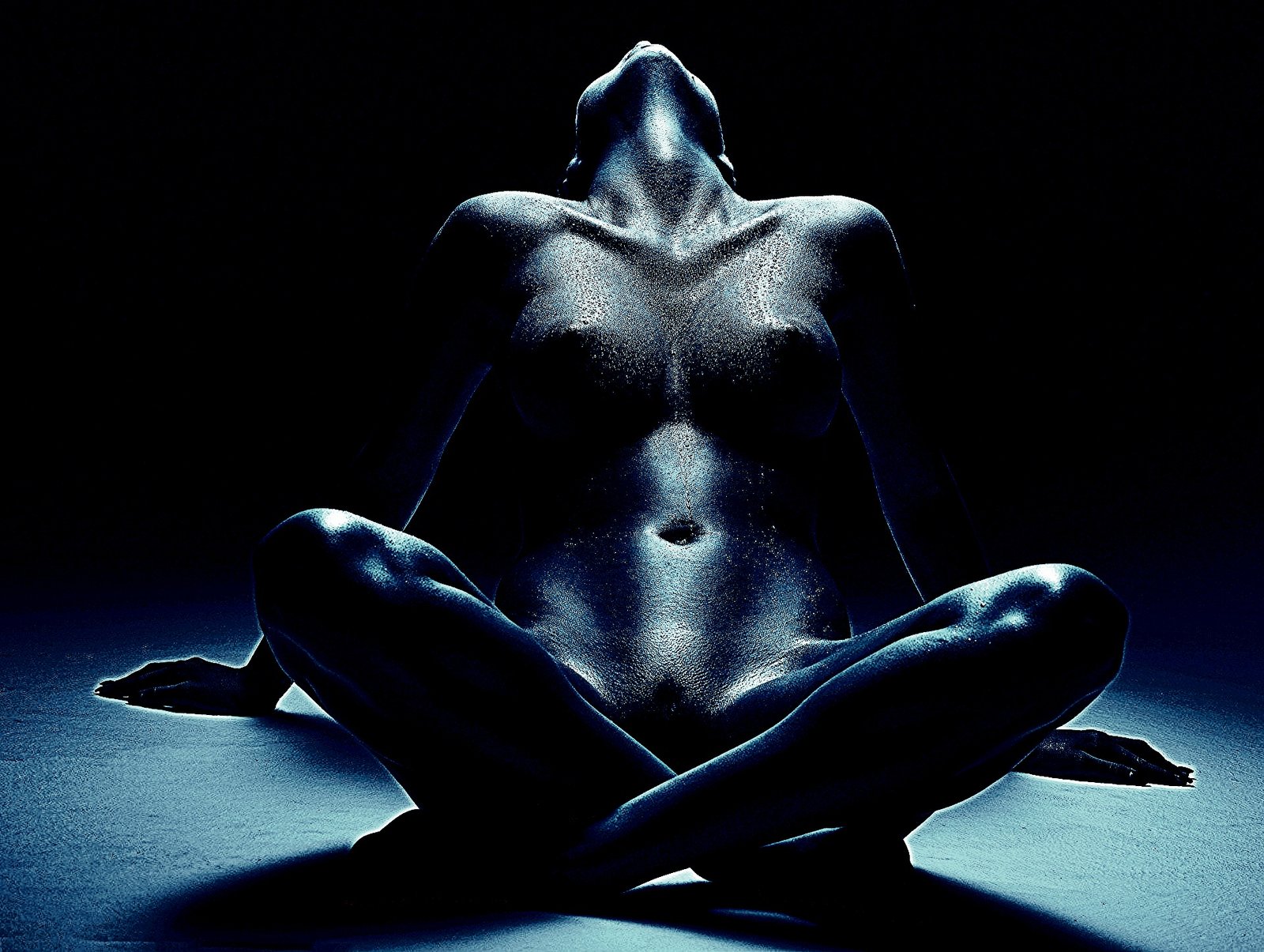 Silhouette of a person in low-key lighting highlighting form and texture