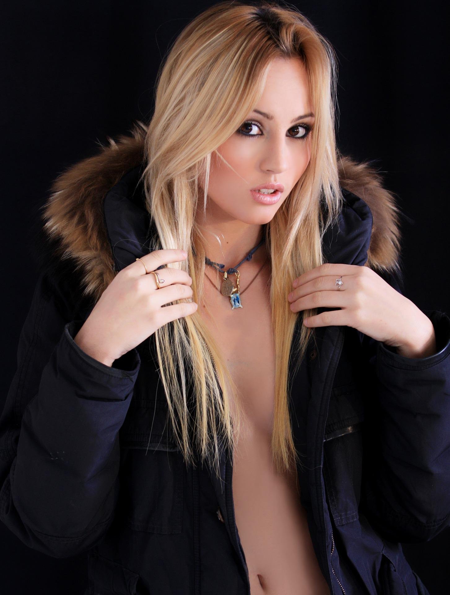 A blonde woman in a black jacket with gothic jewelry, representing the modern adaptation of gothic style in everyday wear.