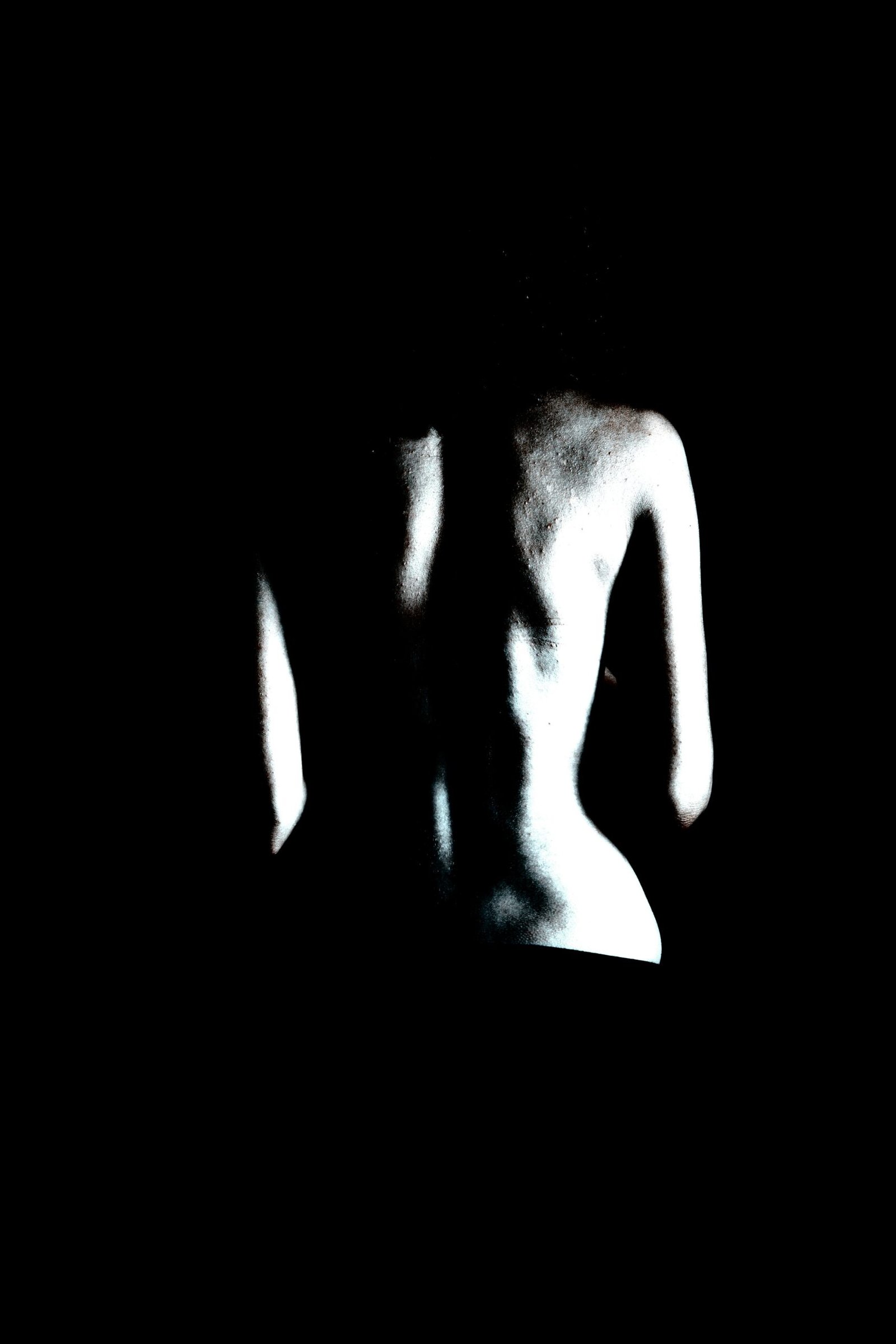 Dramatic high-contrast image of a woman's profile in shadow