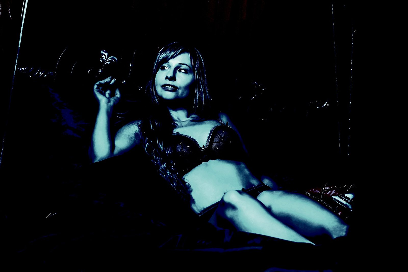 Woman posing in black lingerie with a dark and enigmatic expression