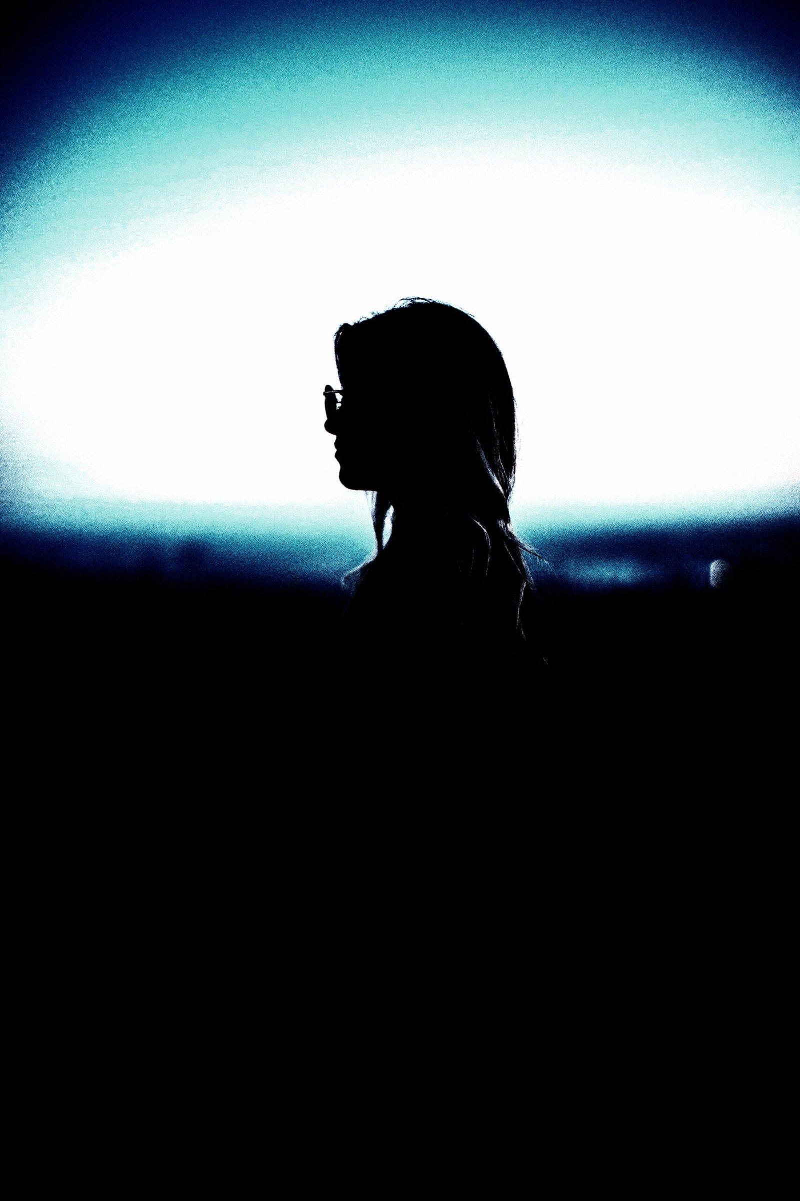 Silhouette of a thoughtful woman against a luminous sky, contemplating 'red flags in a woman' in relationships.
