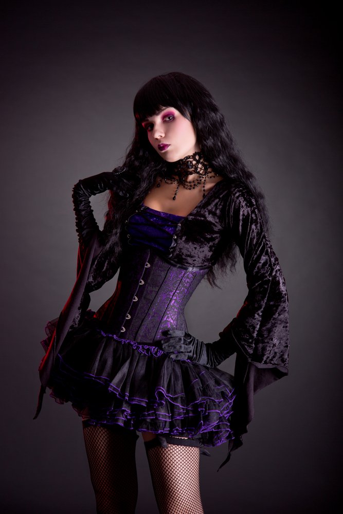 Majestic gothic model with a raven black hairstyle and a velvet corset dress, creating a striking silhouette against a red-hued smoke backdrop.