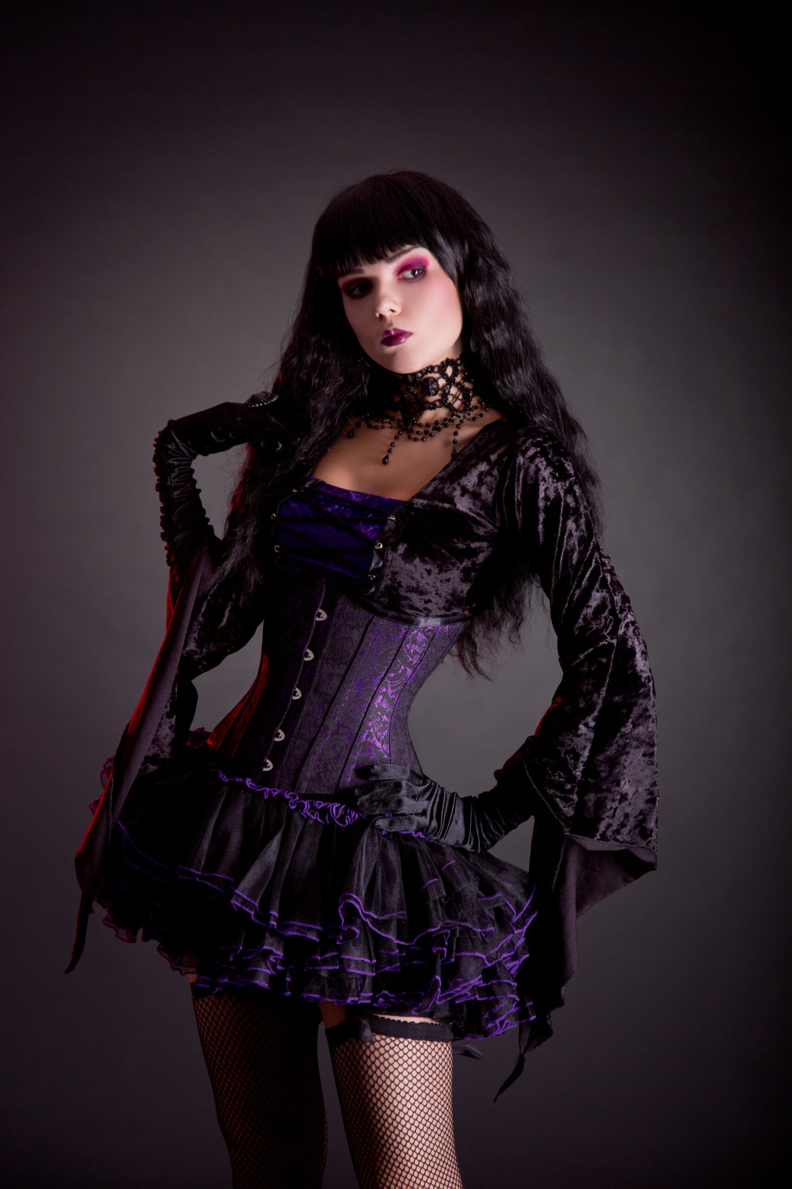 A gothic fantasy comes to life with a model in a velvet corset dress, complete with intricate detailing and an air of mystique.