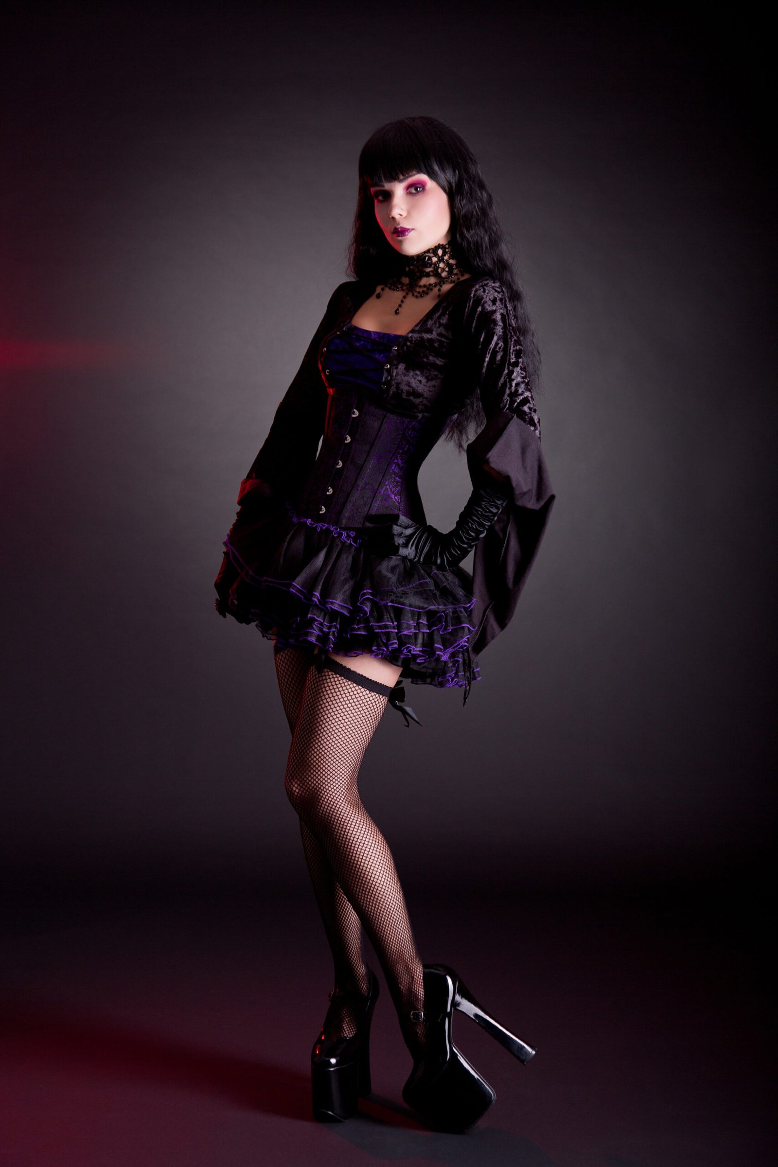 Enchanting gothic beauty showcasing a velvet corset dress with delicate lace trim, exuding elegance in a misty setting.