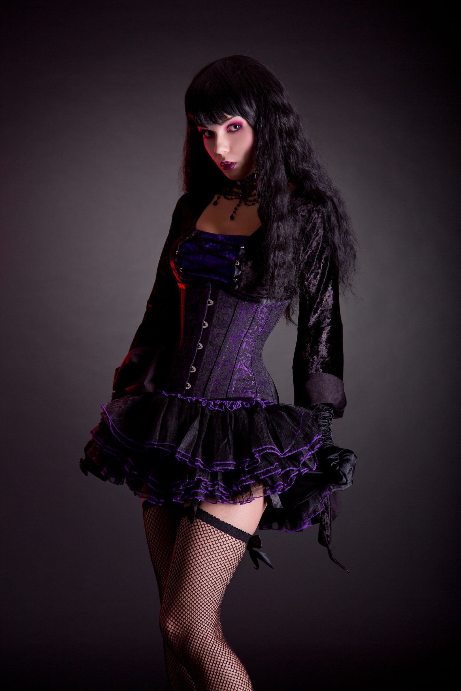Full-length view of a gothic-inspired outfit featuring a velvet corset dress with sumptuous purple and black layers.