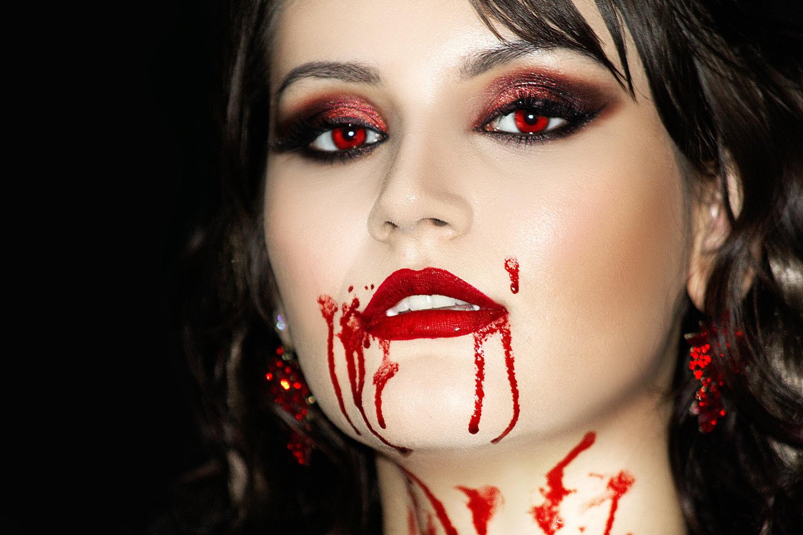 Close-up of a woman with blood dripping from her mouth, featuring dramatic makeup for a Hot Vampire Halloween Costume.
