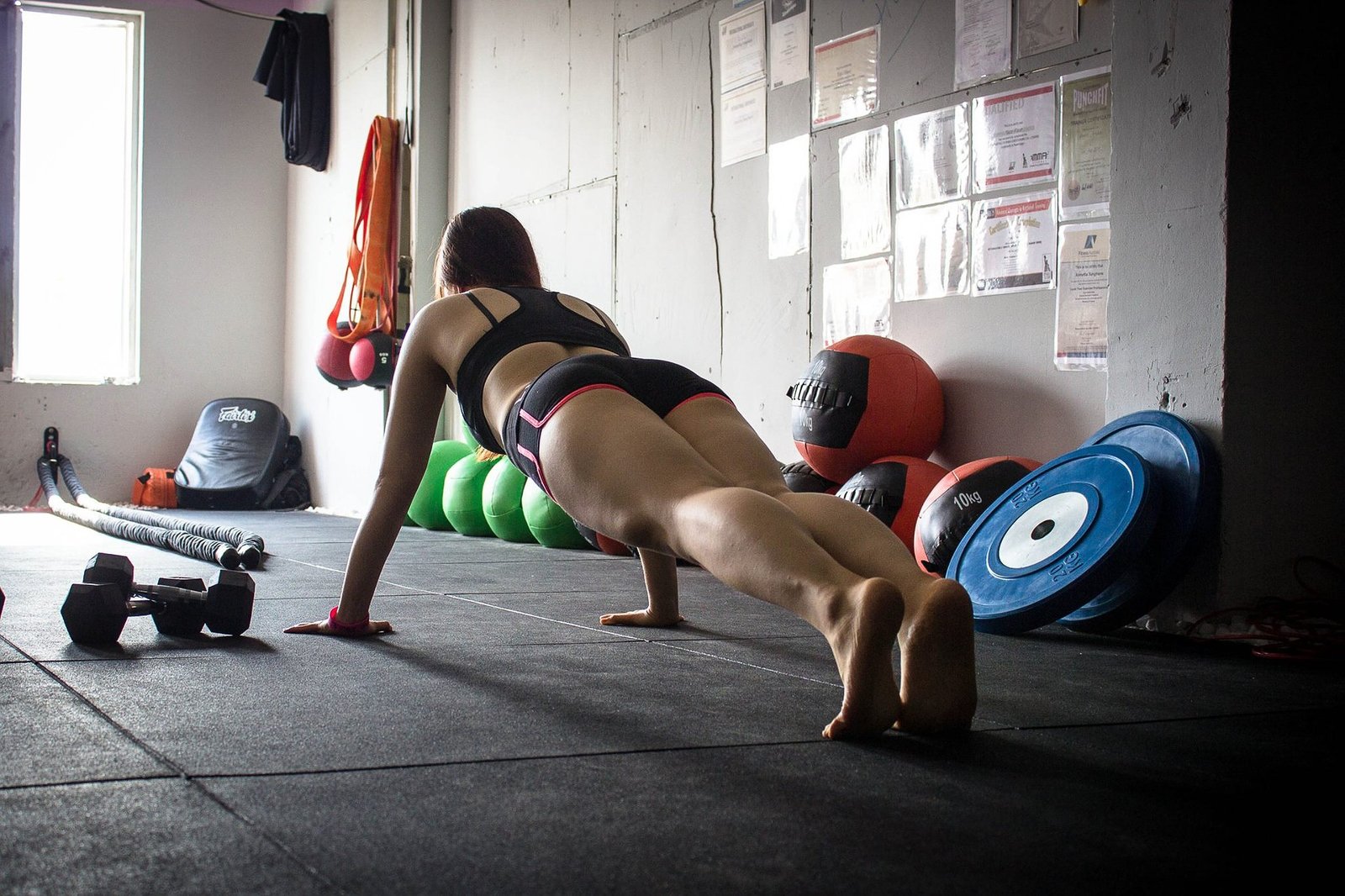 Woman doing plank exercise in gym with focus on form and strength.