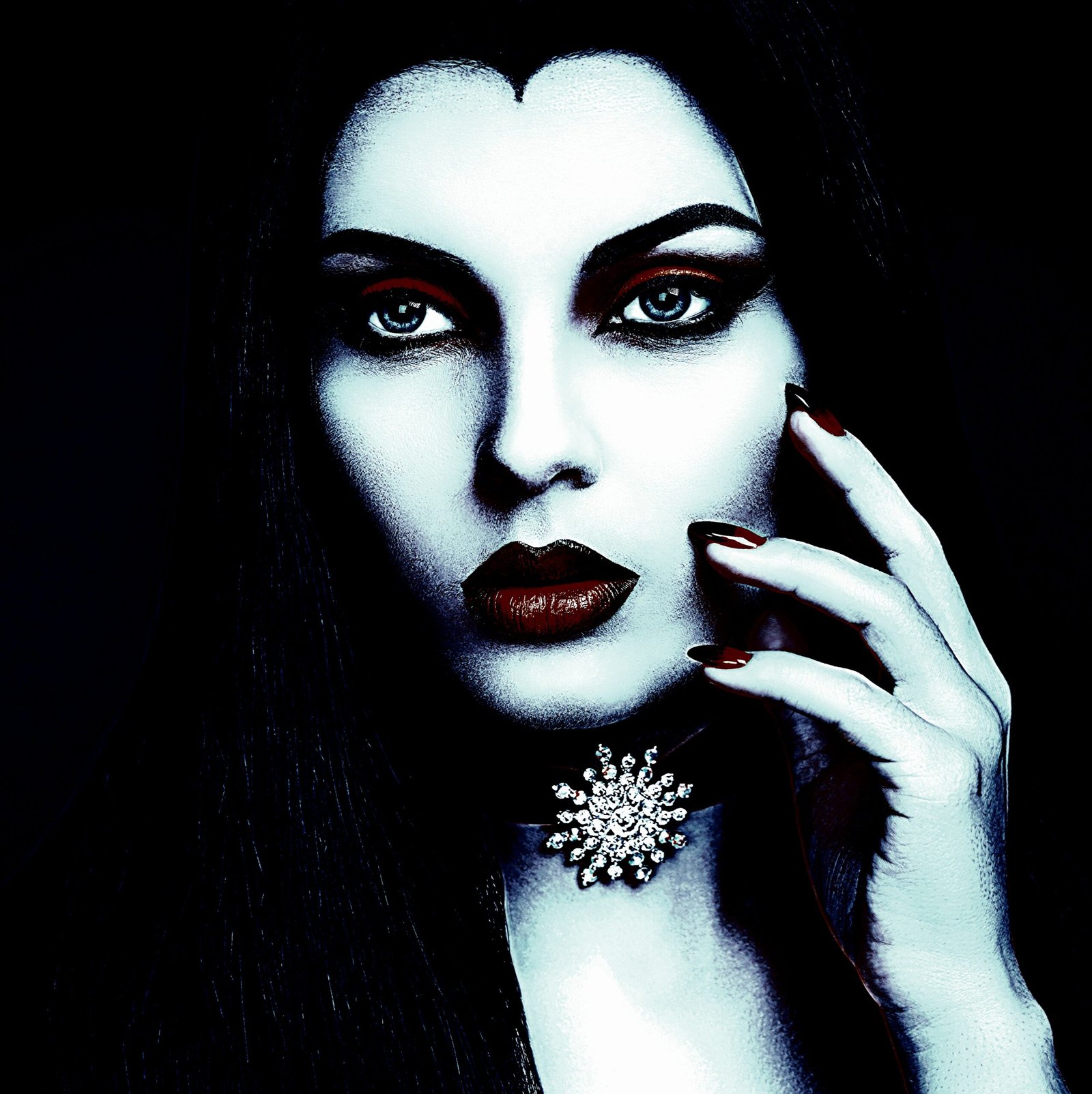Gothic jewelry in a dark setting with a woman wearing an ornate necklace and lace gloves.