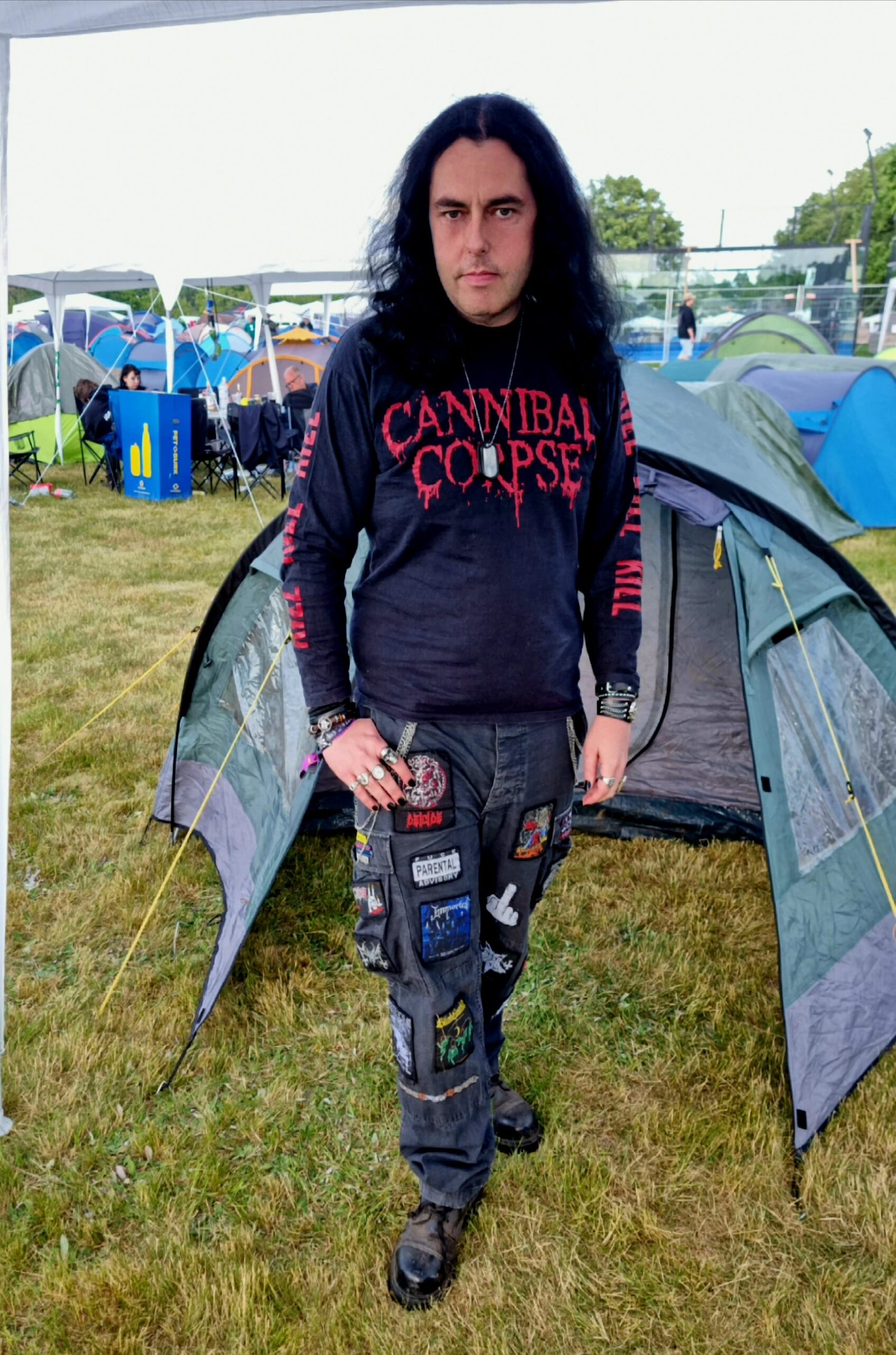 Man in a Cannibal Corpse shirt standing in front of a tent at Sweden Rock Festival 2024