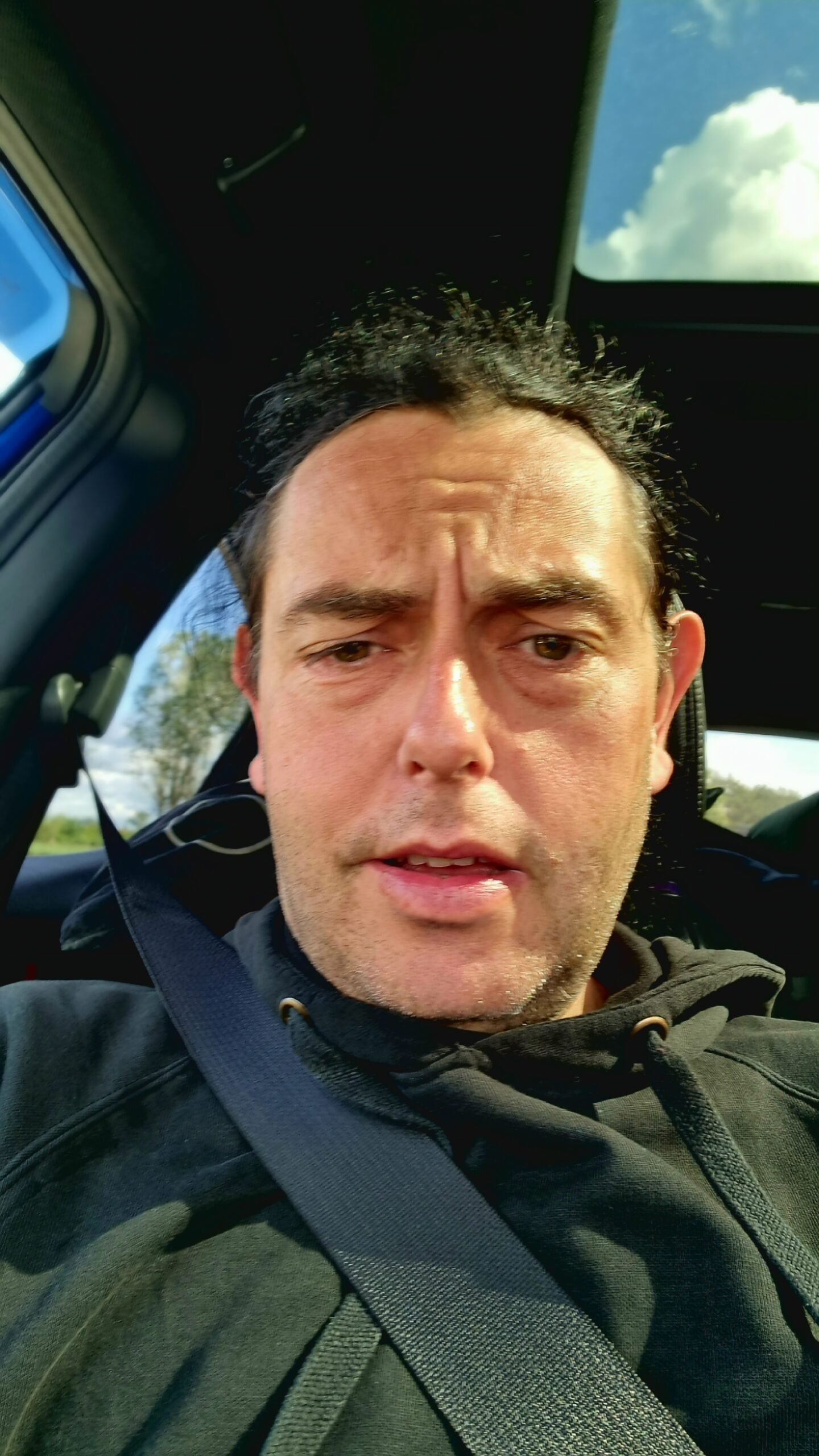 Man taking a selfie inside a car wearing a black hoodie at Sweden Rock Festival 2024