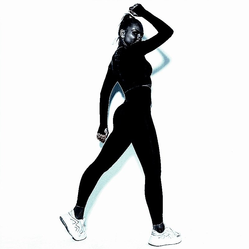Athletic woman in a cropped top and leggings, embodying the essence of Heavy Metal Yoga
