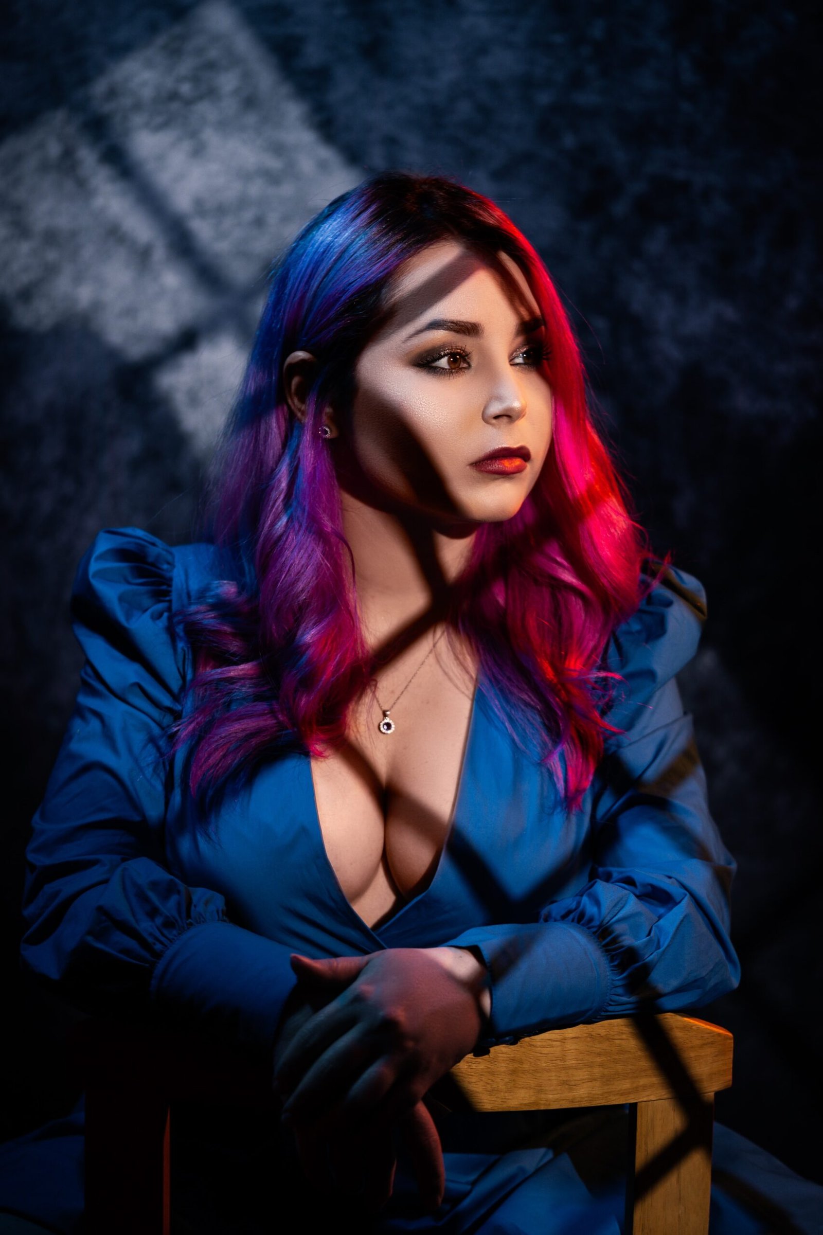 Sexy business woman with vibrant pink and purple hair in a blue dress