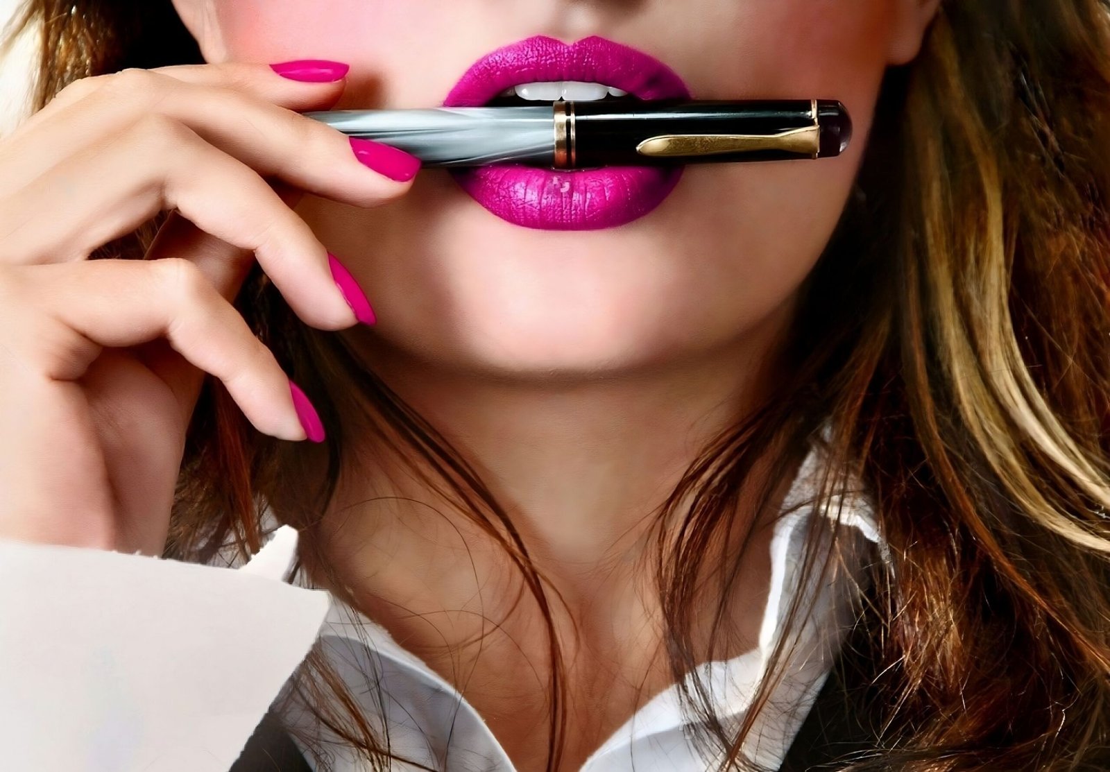 Close-up of a sexy business woman with pink lipstick holding a pen