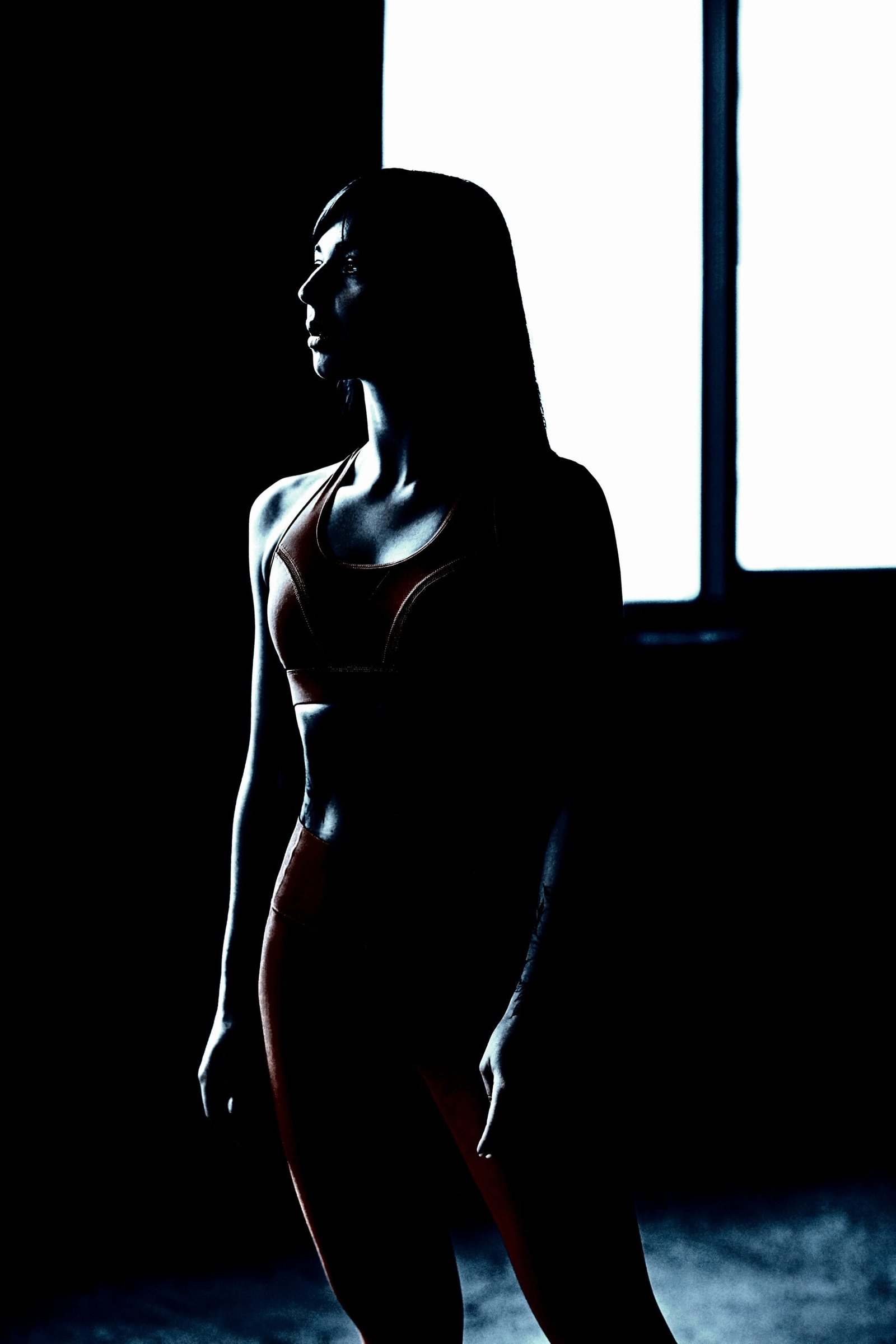 Silhouette of a woman in a powerful pose, emphasizing the dark and empowering nature of Heavy Metal Yoga