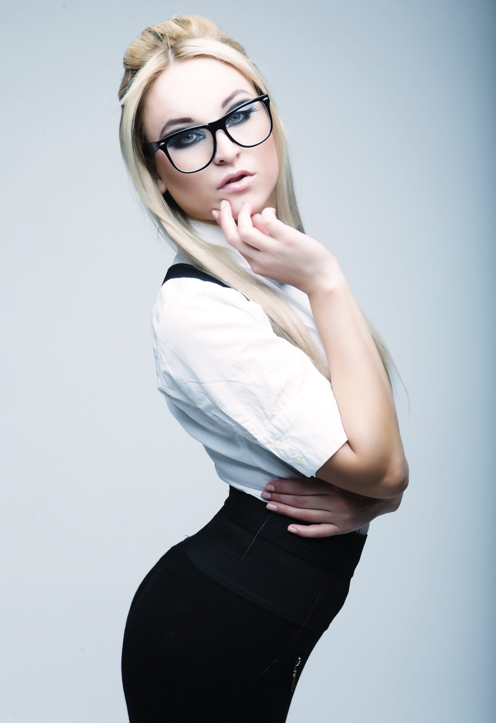 Sexy business woman with glasses in a white shirt and black skirt