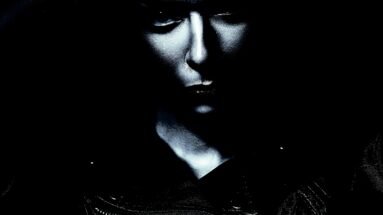 Victorian Gothic blouses: A gothic woman with a piercing gaze, her face partially obscured by shadows, wearing a black leather jacket.