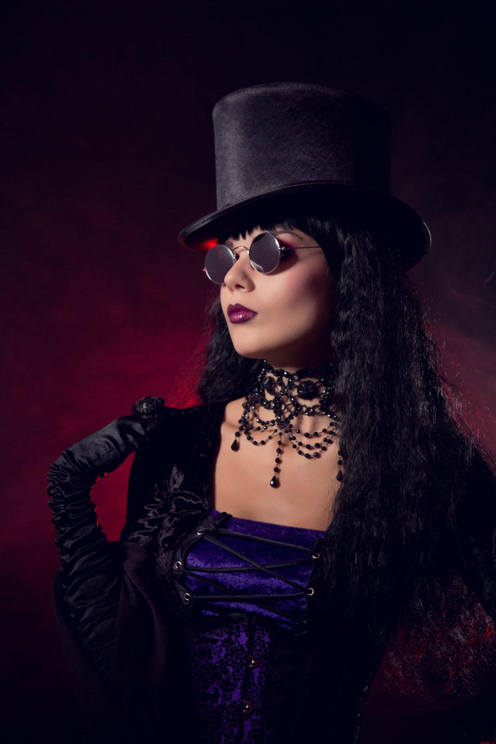 Gothic woman wearing a top hat and Witchy Fishnet Goth Mini Skirt Outfit with a choker necklace