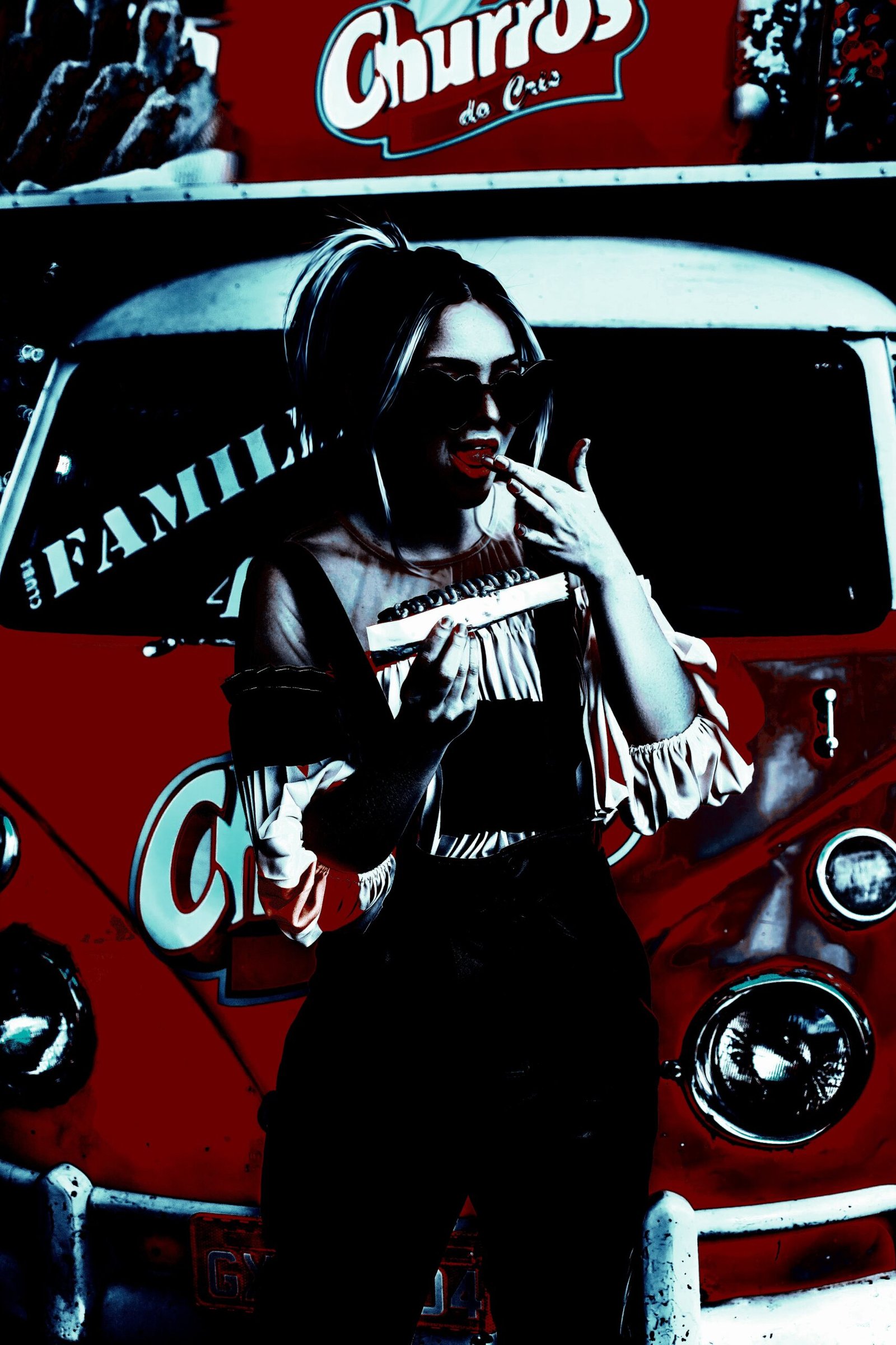 Person sitting in a dimly lit urban setting, wearing dark sunglasses and a pensive expression.