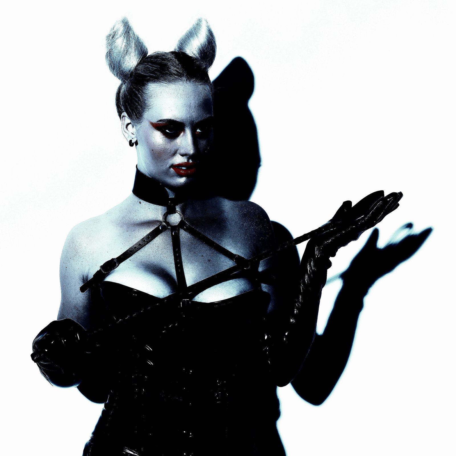 A woman holding a whip in BDSM attire, illustrating the exploration of pain thresholds and emotional catharsis in BDSM.