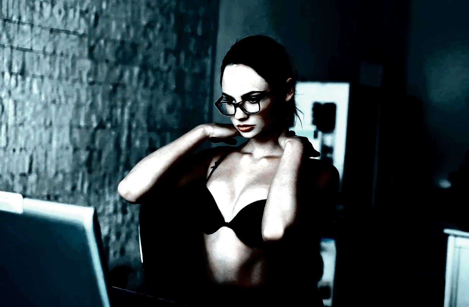 Woman in black lingerie and glasses looking at her reflection, with an intense and focused expression