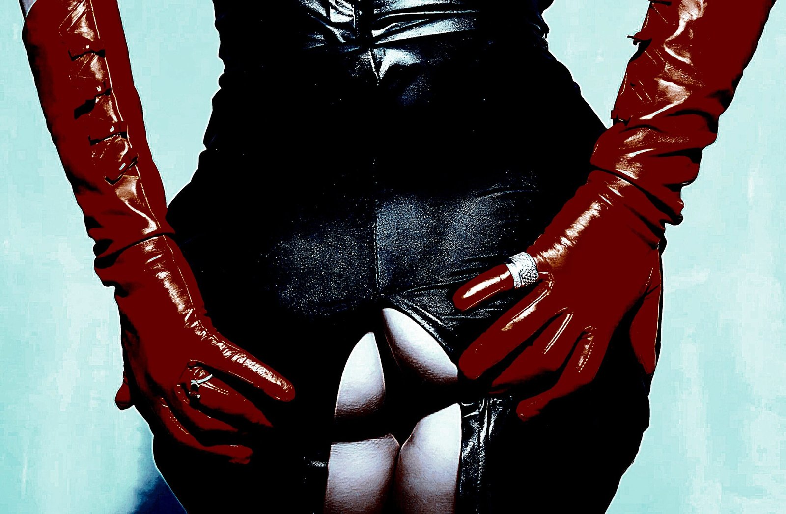 Scat Play: Close-up of a person wearing tight black latex pants and red gloves, with the pants unzipped to reveal bare skin.