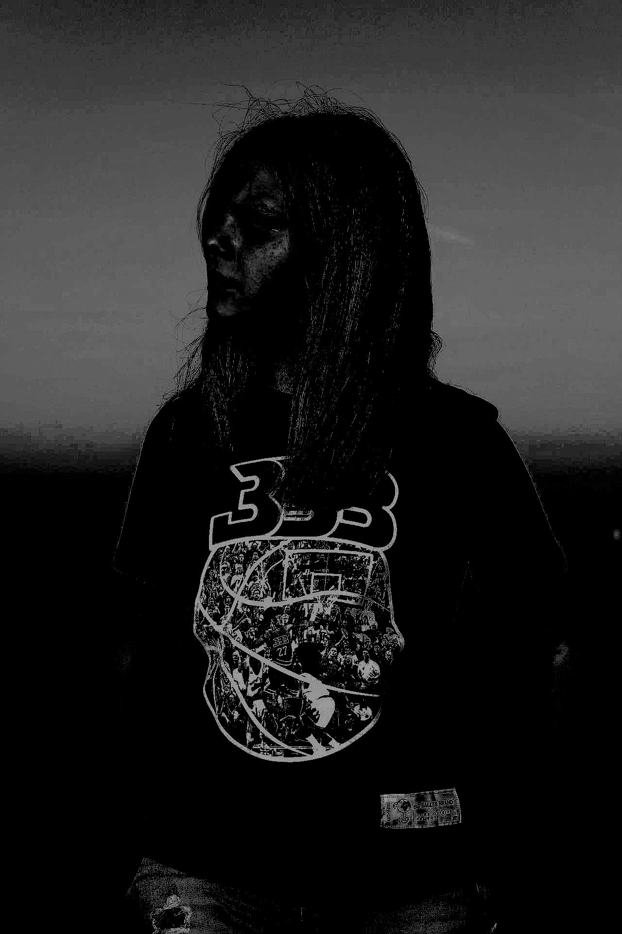 Woman standing against a dark background wearing a T-shirt with a basketball-themed graphic.