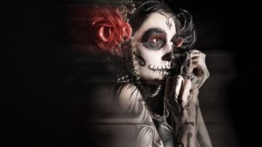 Woman with Day of the Dead face paint, holding a string of beads, exuding a hauntingly beautiful and gothic aesthetic.
