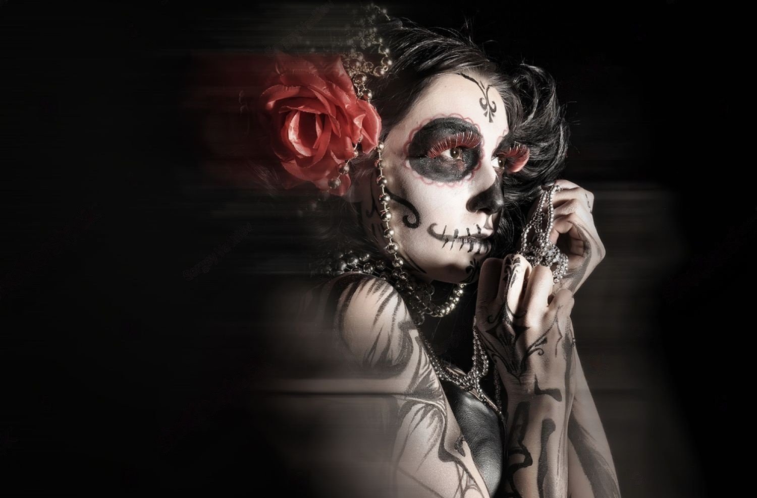 Woman with Day of the Dead face paint, holding a string of beads, exuding a hauntingly beautiful and gothic aesthetic.