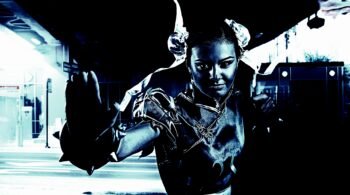 Metalhead cosplayer in a combat-ready pose, dressed as a character with twin buns and ribbons in a dark urban setting.