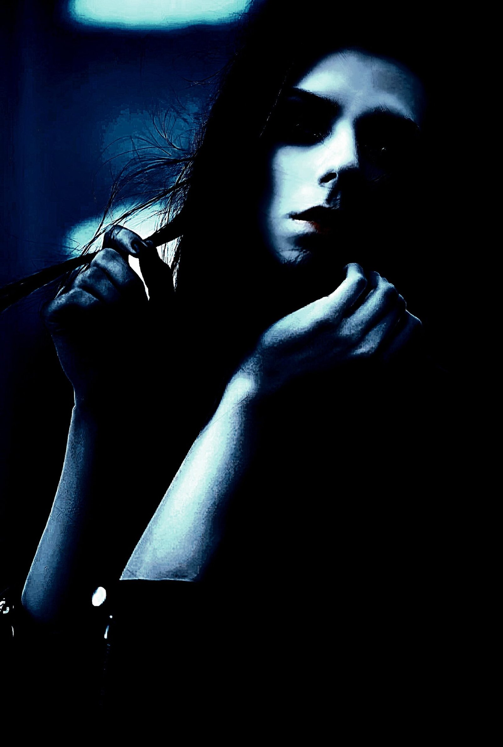 Portrait of a woman in low lighting, her expression intense and mysterious, evoking a sense of dark allure and introspection.