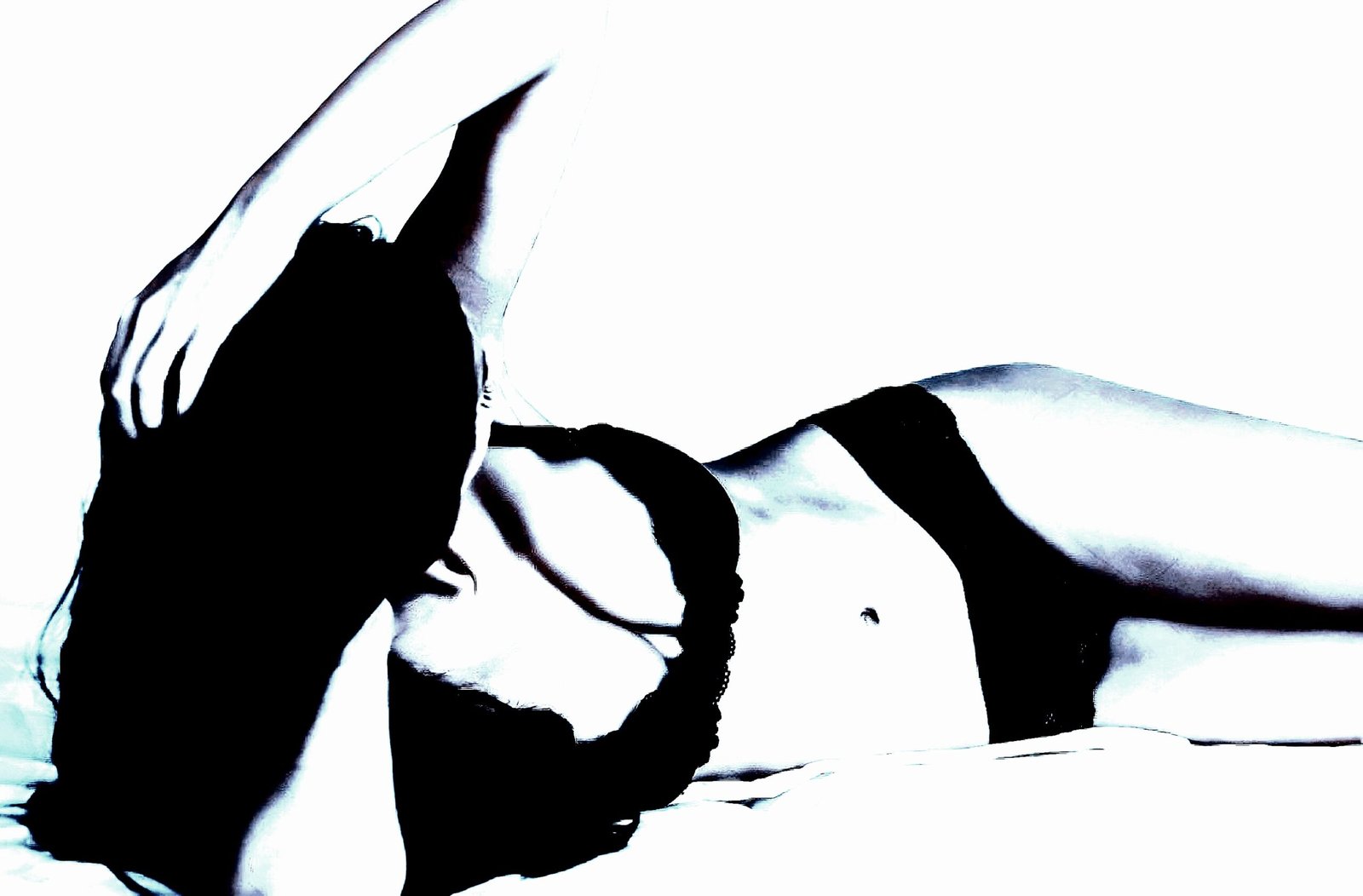 A high-contrast silhouette of a woman reclining in black lingerie, creating a bold and artistic composition.