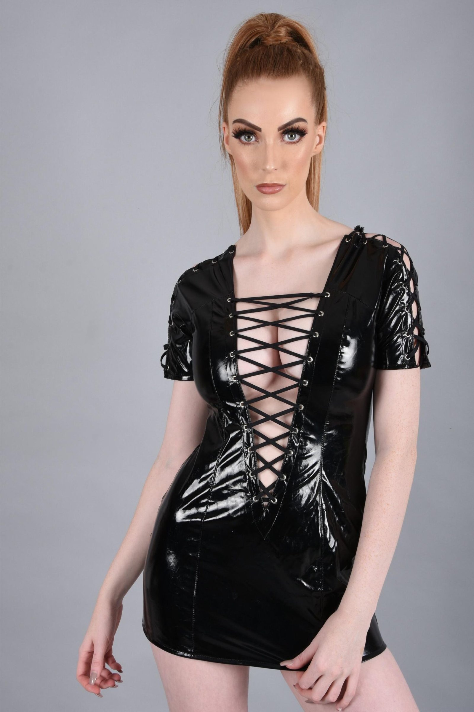 Woman in black vinyl lace-up dress): Woman in a glossy black vinyl mini dress with lace-up detailing, showcasing edgy and seductive gothic style.