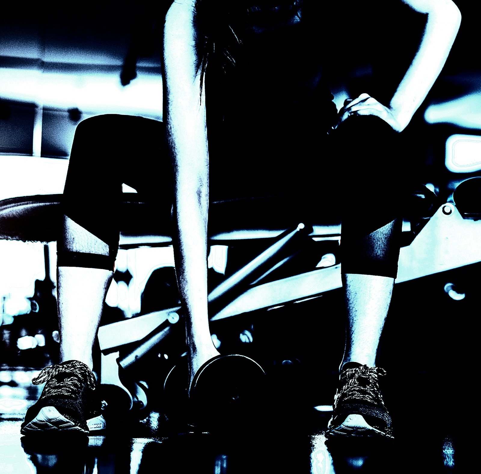 Focused woman preparing to lift a dumbbell during a workout session in a gym, with determination captured through body language.