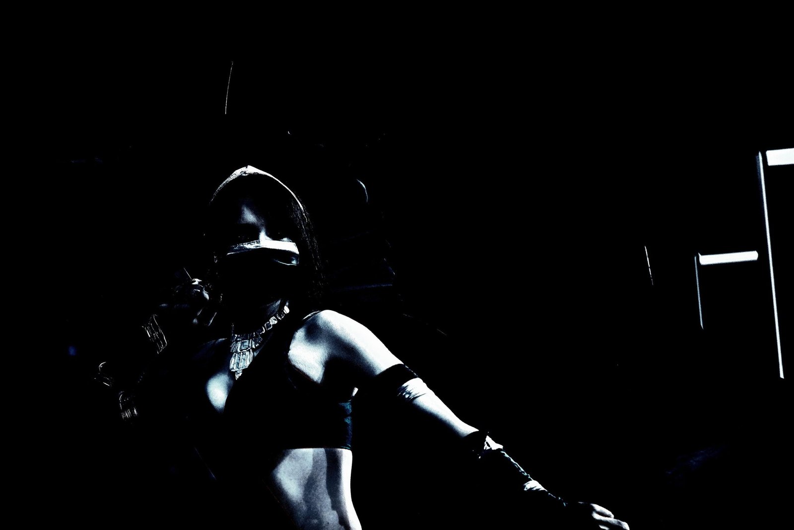 Silhouette of a cosplayer in a dark ninja-inspired costume, shrouded in shadows and exuding an intense, enigmatic vibe.