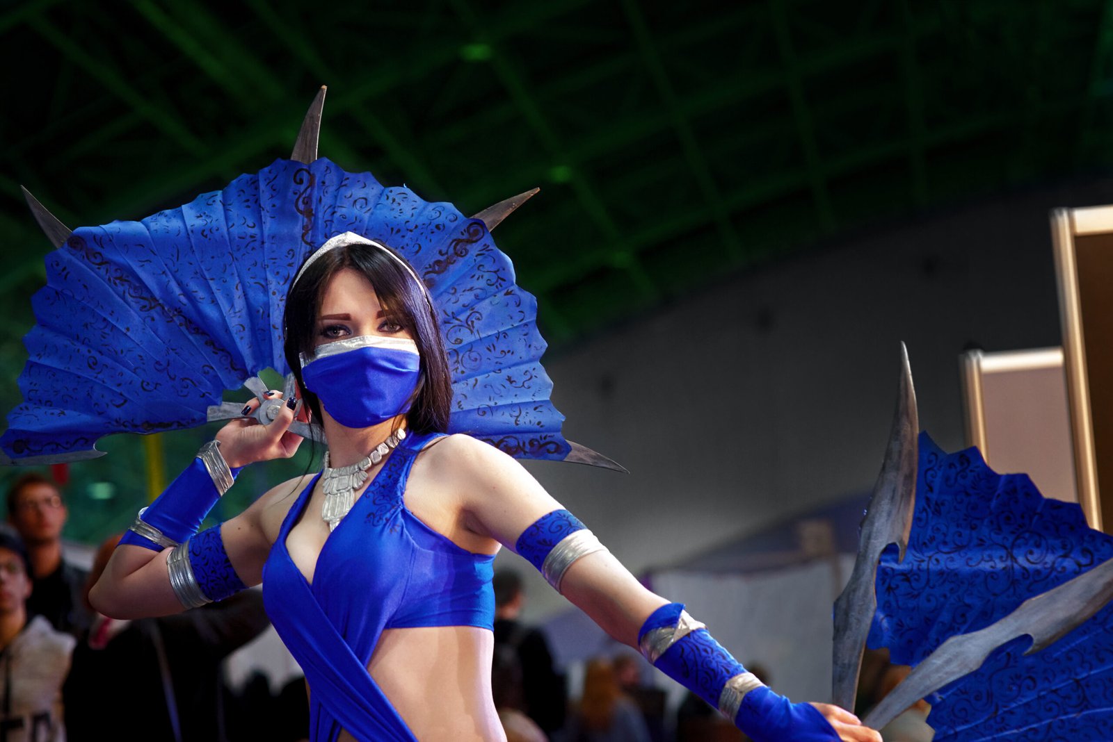 Close-up of Kitana from Mortal Kombat cosplay, standing confidently with her fan weapons ready in hand.