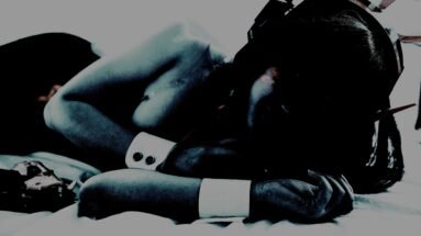 Softly lit cosplay of a character lying down with a bunny-inspired headpiece, evoking a sense of vulnerability and mystery.