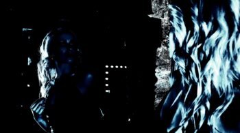 Blonde woman gazing into a mirror in a moody, dramatic light, emphasizing self-reflection and mystery.