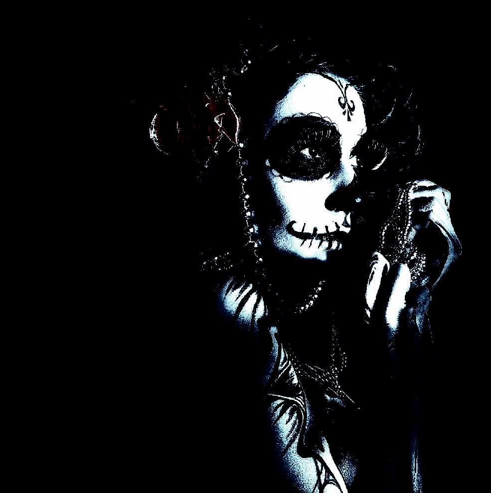 Woman with skull makeup and gothic tattoos, in an eerie and haunting Day of the Dead-inspired look.
