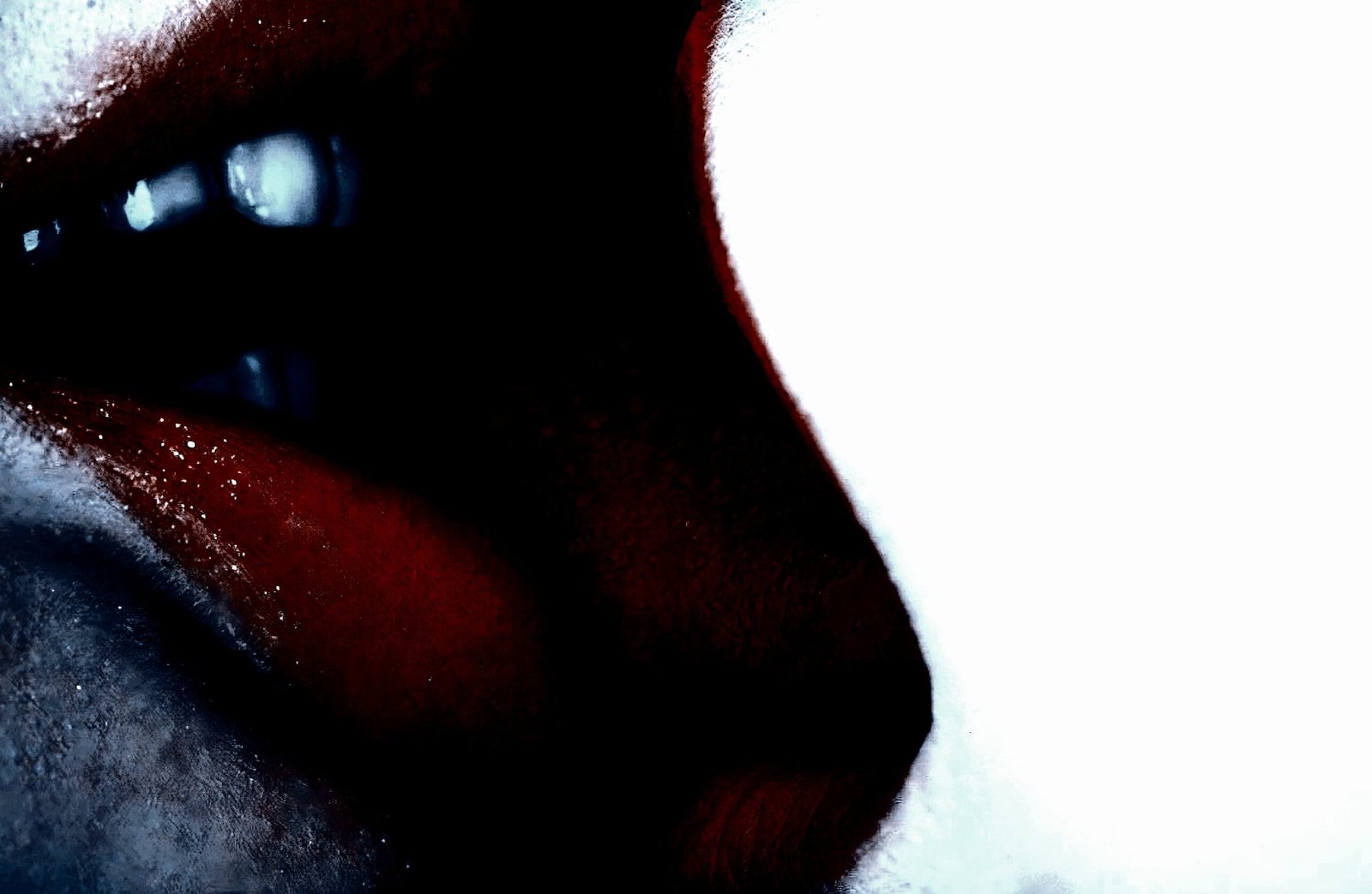Close-up of darkly painted lips and a partial face, with shadows creating a mysterious and alluring atmosphere. 